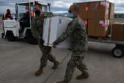 US Navy Sailors with Defense Logistics Agency Distribution Sigonella, prepare and load a box of COVID-19 vaccines to be shipped to the Nimitz-class aircraft carrier USS Dwight D. Eisenhower (CVN 69) from Naval Air Station Sigonella.