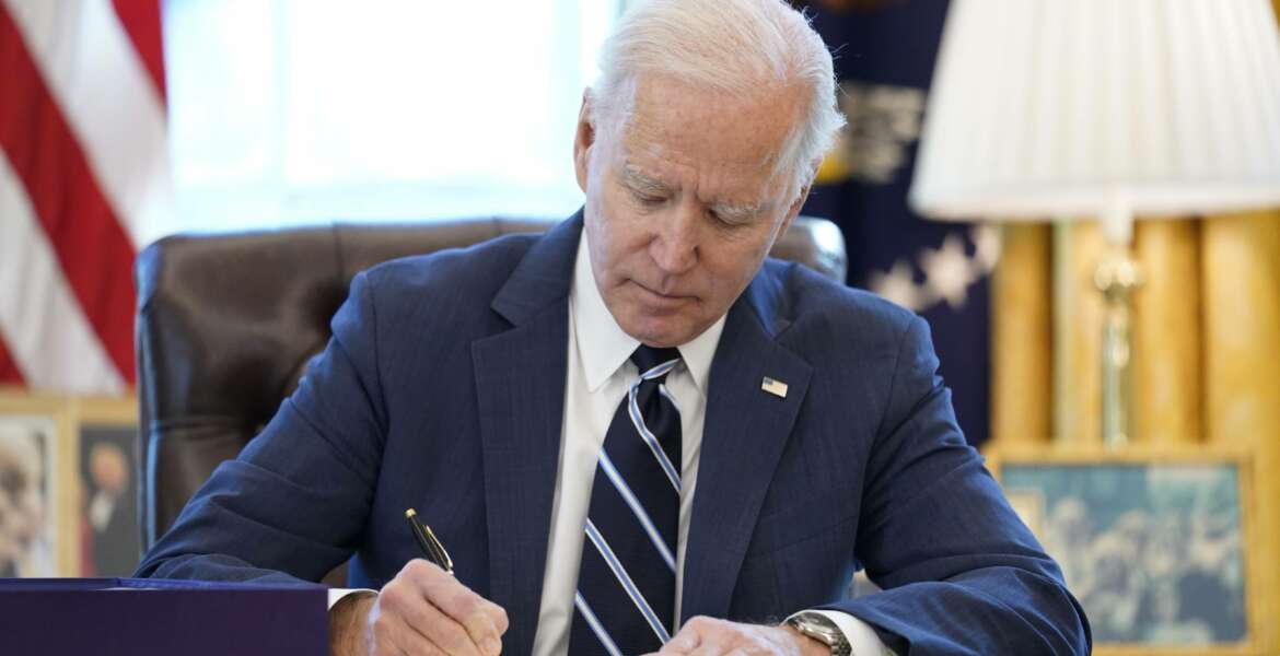 President Joe Biden signs the American Rescue Plan, a coronavirus relief package, in the Oval Office of the White House, Thursday, March 11, 2021, in Washington. (AP Photo/Andrew Harnik)