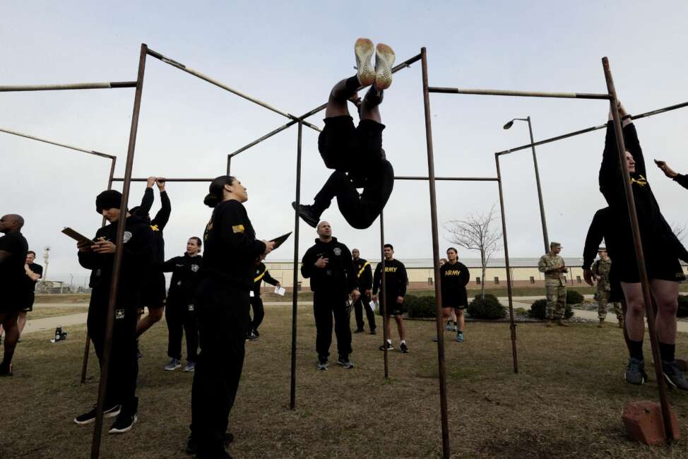 FILE - In this Jan. 8, 2019, file photo, U.S Army troops training to serve as instructors participate in the new Army combat fitness test at the 108th Air Defense Artillery Brigade compound at Fort Bragg, N.C. Army leaders are kicking out the requirement that soldiers do at least one leg tuck as part of the new physical fitness test, after finding many troops — particularly women — were unable to do the exercise that requires them to raise their knees while hanging from a bar.  (AP Photo/Gerry Broome, File)