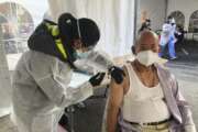 FILE - In this Feb. 8, 2021, file photo, Victor Villegas, 78, right, receives a COVID-19 vaccine shot from a health care worker at a vaccination site in the Mission district of San Francisco. As Newsom faces a likely recall, Latino advocates say engaging their communities and providing a more robust response to the pandemic could be keys to his survival. (AP Photo/Haven Daley, File)