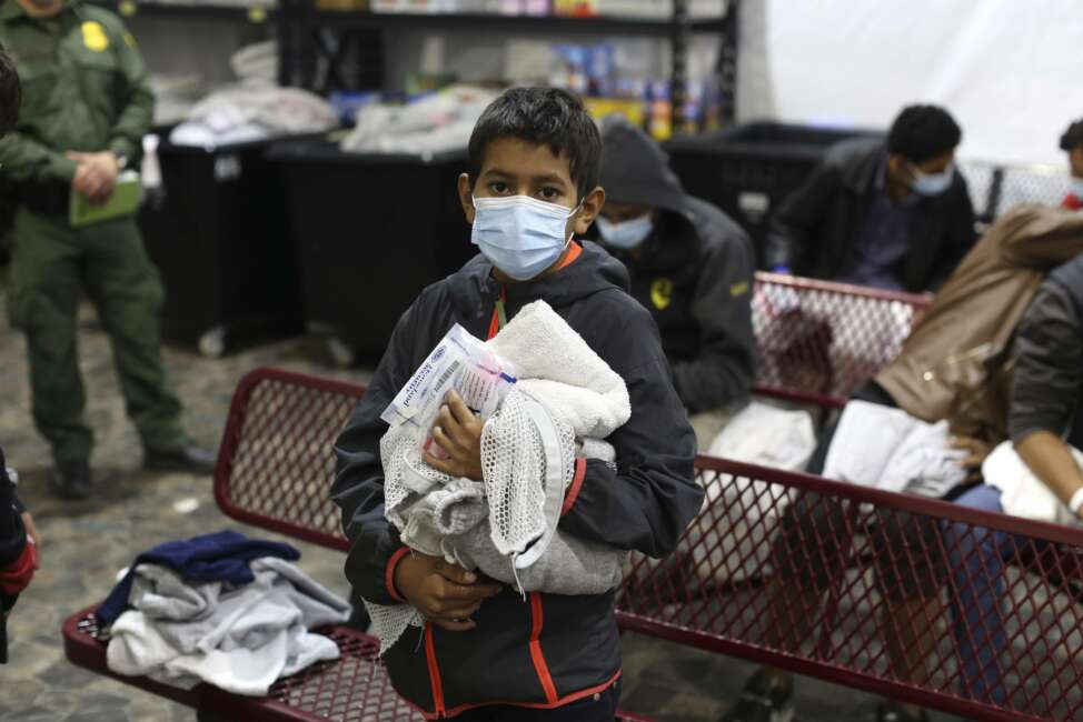 A young migrant waits for his turn to take a shower at the Donna Department of Homeland Security holding facility, the main detention center for unaccompanied children in the Rio Grande Valley, in Donna, Texas, Tuesday, March 30, 2021. (AP Photo/Dario Lopez-Mills, Pool)