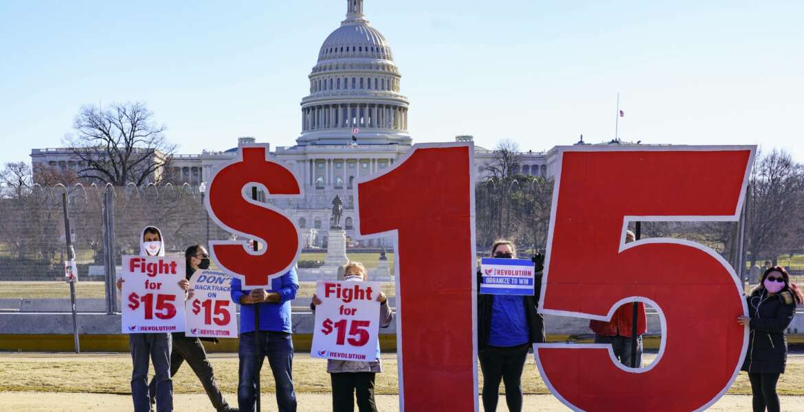 Activists appeal for a $15 minimum wage near the Capitol in Washington, Thursday, Feb. 25, 2021. The $1.9 trillion COVID-19 relief bill being prepped in Congress includes a provision that over five years would hike the federal minimum wage to $15 an hour. (AP Photo/J. Scott Applewhite)