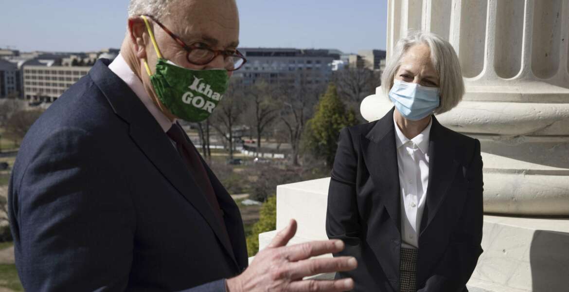 Senate Majority Leader Chuck Schumer of N.Y., speaks as Karen Gibson, the new Sergeant at Arms of the United States Senate, listens outside Schumer's office, Monday, March 22, 2021, at the Capitol in Washington. (Graeme Jennings/Pool via AP)