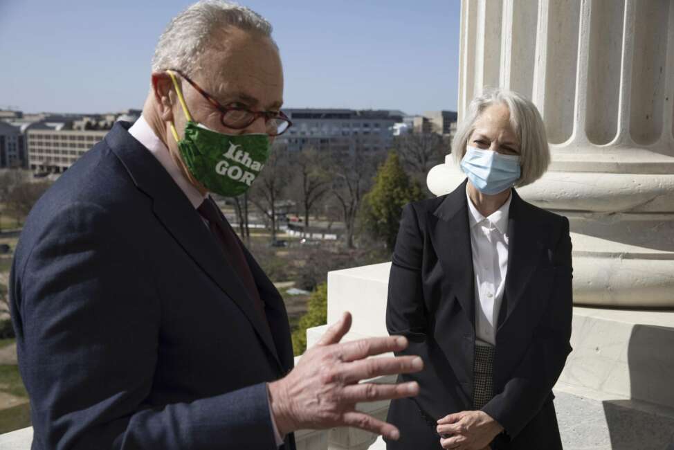 Senate Majority Leader Chuck Schumer of N.Y., speaks as Karen Gibson, the new Sergeant at Arms of the United States Senate, listens outside Schumer's office, Monday, March 22, 2021, at the Capitol in Washington. (Graeme Jennings/Pool via AP)