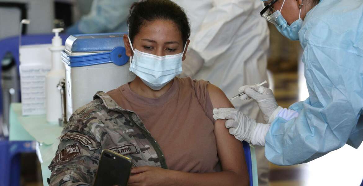An Air Force member takes a selfie while getting her shot of the Pfizer vaccine for COVID-19 at a military base in Lima, Peru, Monday, March 8, 2021. (AP Photo/Martin Mejia)