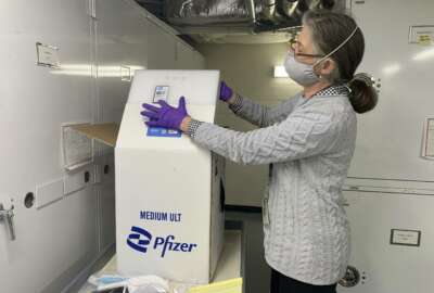 Curator Diane Wendt shows that specialized container used to ship super cold doses of the Pfizer COVID-19 vaccine in Washington, on Monday, March 8, 2021. The package and other items related to the first dose of vaccine administered in the U.S. have been donated to the Smithsonian's Museum of American History. (AP Photo/Ashraf Khalil)