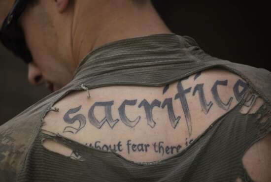 A tattoo on the back of U.S. Army Sgt. James Wilkes of Rochester, N.Y., is seen through his torn shirt after a foot patrol with 1st Platoon, Charlie Company, 2nd Battalion, 1st Infantry Regiment, of the 5th Styker Brigade on May 8, 2010, in Afghanistan's Kandahar province. The full tattoo reads, 
