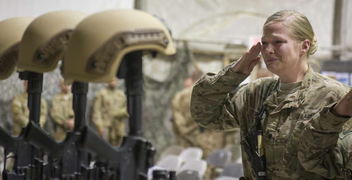 FILE - In this Dec. 23, 2015 file photo, a U.S. service member salutes her fallen comrades during a memorial ceremony for six Airmen killed in a suicide attack, at Bagram Air Field, Afghanistan. ter 20 years America is ending its “forever” war in Afghanistan. There’s conflicting views even among U. S. military minds as to  whether the time is right. For others there is another lingering question: Was it worth it? (Tech. Sgt. Robert Cloys/U.S. Air Force via AP)