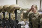 FILE - In this Dec. 23, 2015 file photo, a U.S. service member salutes her fallen comrades during a memorial ceremony for six Airmen killed in a suicide attack, at Bagram Air Field, Afghanistan. ter 20 years America is ending its “forever” war in Afghanistan. There’s conflicting views even among U. S. military minds as to  whether the time is right. For others there is another lingering question: Was it worth it? (Tech. Sgt. Robert Cloys/U.S. Air Force via AP)