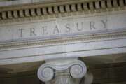 FILE- This June 6, 2019, file photo shows the U.S. Treasury Department building at dusk in Washington.  The U.S. Treasury has removed Vietnam and Switzerland from the list of nations labeled as currency manipulators, reversing a decision made by the Trump administration in December. In it's semi-annual report to Congress on currency manipulation, the first under the Biden administration, the U.S. Treasury Department said Friday, April 16, 2021,  that no country currently meets the U.S. criteria. It said, however, that Vietnam, Switzerland, as well as Taiwan, will be placed under enhanced monitoring for their recent actions. (AP Photo/Patrick Semansky, File)