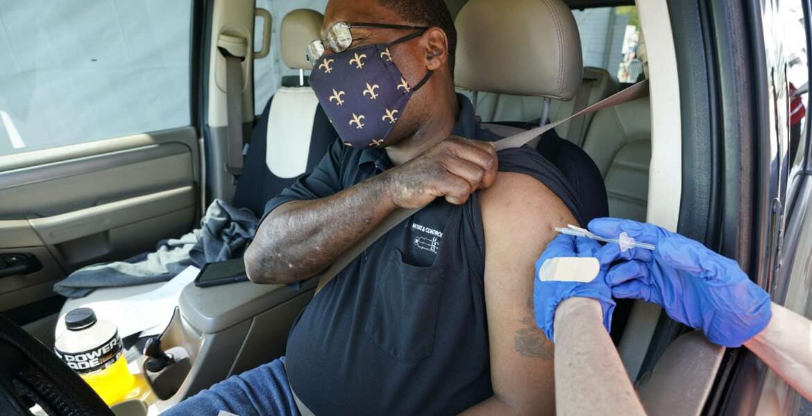 FILE - In this March 29, 2021, file photo, Brian Snipes receives a drive-thru vaccination at 