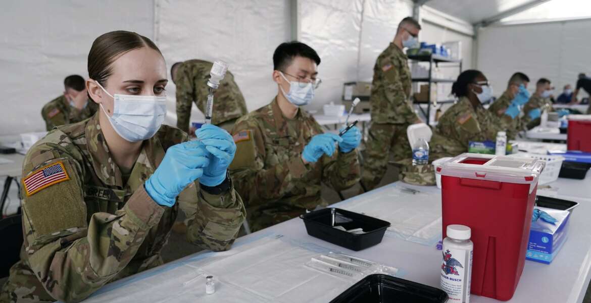 FILE - In this March 9, 2021, file photo, Army health specialists fill syringes with the Pfizer COVID-19 vaccine in Miami. Despite the clamor to speed up the U.S. vaccination drive against COVID-19, the first three months of the rollout suggest faster is not necessarily better. (AP Photo/Marta Lavandier, File)