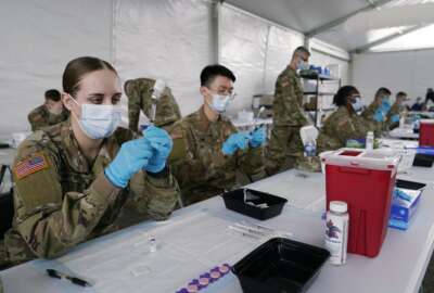 FILE - In this March 9, 2021, file photo, Army health specialists fill syringes with the Pfizer COVID-19 vaccine in Miami. Despite the clamor to speed up the U.S. vaccination drive against COVID-19, the first three months of the rollout suggest faster is not necessarily better. (AP Photo/Marta Lavandier, File)