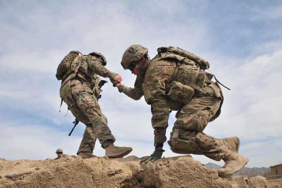 A Soldier helps a fellow Soldier onto the rooftop of a building in order to provide protective overwatch for another element of their patrol in Afghanistan Jan. 29, 2012. Army senior leaders recently discussed the importance of suicide prevention and recognizing warning signs after the service reported an increase in suicides among active-duty Soldiers in 2020. (Sgt. Kimberly Hackbarth)