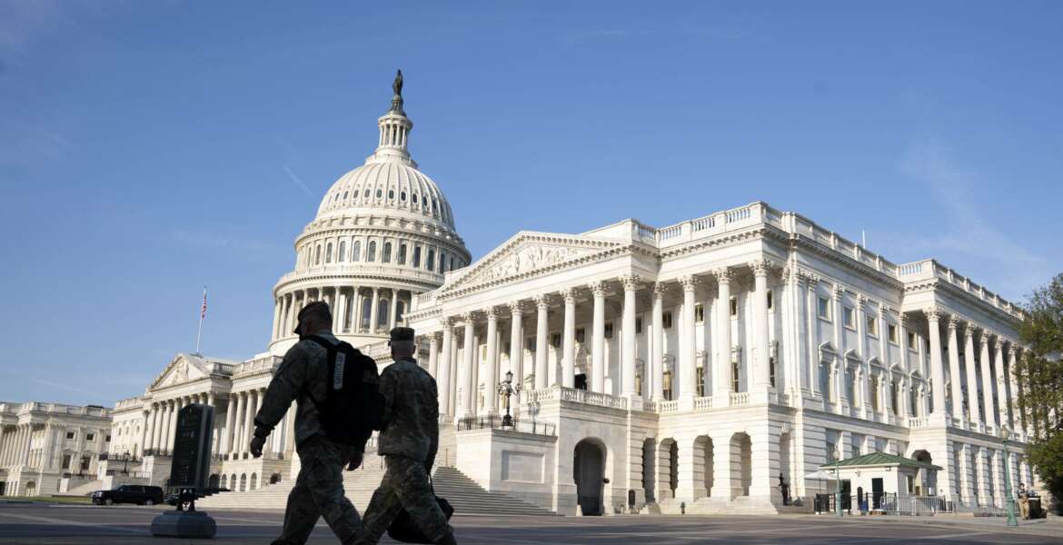 The U.S. Capitol is seen as national guard members pass by on Capitol Hill in Washington, Thursday, May 20, 2021. The House voted to create an independent commission on the deadly Jan. 6 insurrection at the U.S. Capitol, sending the legislation to an uncertain future in the Senate. (AP Photo/Jose Luis Magana)