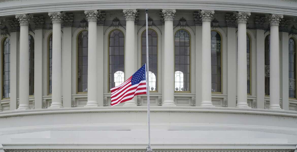 FILE - In this Jan. 8, 2021 file photo, an American flag flies at half-staff in remembrance of U.S. Capitol Police Officer Brian Sicknick above the Capitol Building in Washington.  (AP Photo/Patrick Semansky)