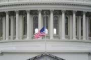 FILE - In this Jan. 8, 2021 file photo, an American flag flies at half-staff in remembrance of U.S. Capitol Police Officer Brian Sicknick above the Capitol Building in Washington.  (AP Photo/Patrick Semansky)