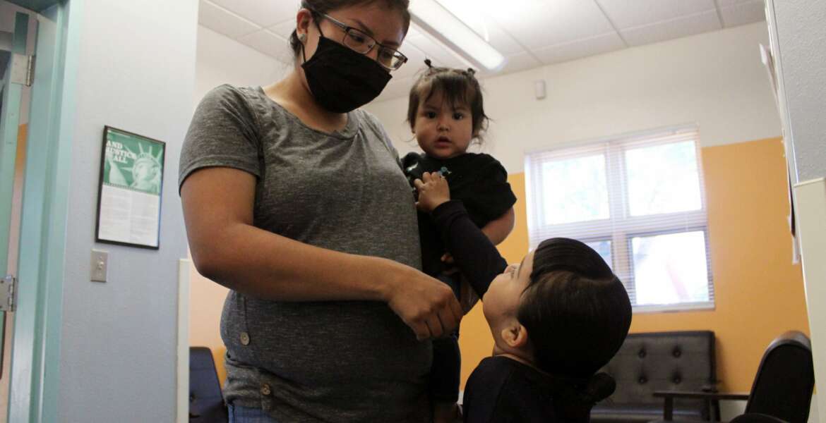 This May 17, 2021 image shows Charrae Toledo dropping off her daughters for the day at Cuidando Los Ninos in Albuquerque, N.M. The charity provides housing, child care and financial counseling for mothers, all of whom will benefit from expanded Child Tax Credit payments that will start flowing in July to roughly 39 million households. (AP Photo/Susan Montoya Bryan)