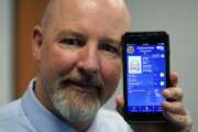 Ryan Williams, with the Utah Drivers License Division, displayes his cell phone with the pilot version of the state's mobile ID on Wednesday, May 5, 2021, in West Valley City, Utah. The card that millions of people use to prove their identity to everyone from police officers to liquor store owners may soon be a thing of the past as a growing number of states develop digital driver's licenses. In Utah, over 100 people have a pilot version of the state's mobile ID, and that number is expected to grow to 10,000 by year's end. Widespread production is expected to begin at the start of 2022. (AP Photo/Rick Bowmer)