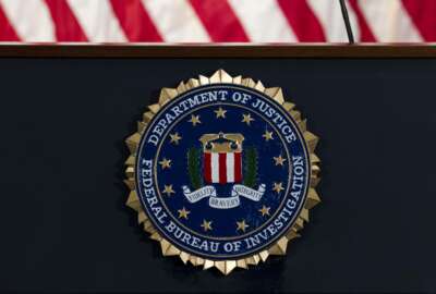 FILE - In this June 14, 2018, file photo, the FBI seal is seen before a news conference at FBI headquarters in Washington. An FBI employee has been indicted on charges that she stored classified documents and other national security information at home over the course of more than a decade, the Justice Department said Friday.  (AP Photo/Jose Luis Magana, File)