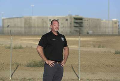 Aaron McGlothin, union president at the Federal Correctional Institution at Mendota, stands in front of the prison during a protest against staffing shortages, near the prison entrance in Mendota, Calif., Monday, May 17, 2021. (AP Photo/Gary Kazanjian)