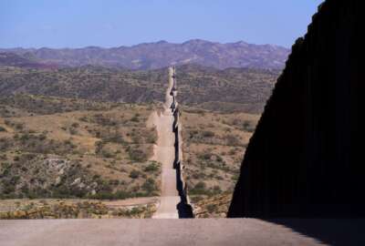 A new border wall stretches along the landscape near Sasabe, Ariz., on Wednesday, May 19, 2021. (AP Photo/Ross D. Franklin)
