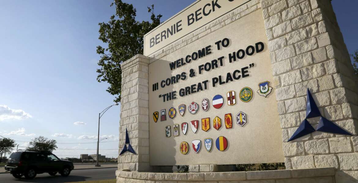 FILE - In this July 9, 2013, file photo, traffic flows through the main gate past a welcome sign in Fort Hood, Texas. A new study finds that female soldiers at Army bases in Texas, Colorado, Kansas and Kentucky face a greater risk of sexual assault and harassment than those at other posts, accounting for more than a third of all active duty Army women sexually assaulted in 2018. The study by RAND Corporation was released Friday.  (AP Photo/Tony Gutierrez, File)