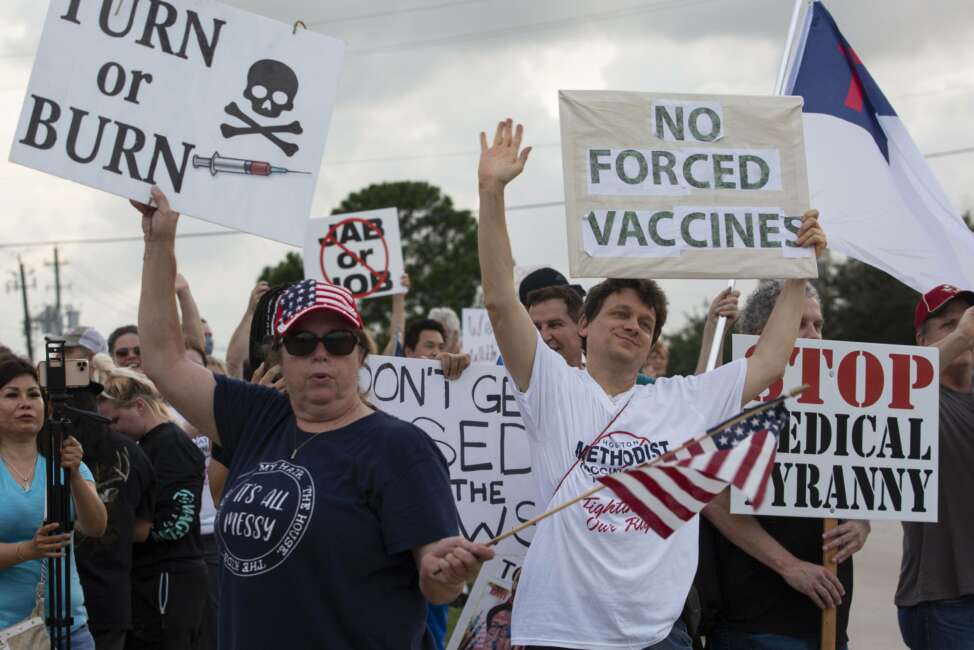 FILE - In this June 7, 2021, file photo, demonstrators at Houston Methodist Baytown Hospital in Baytown, Texas, wave at cars that honk at them to support their protest against a policy that says hospital employees must get vaccinated against COVID-19 or lose their jobs. A  federal judge dismissed their lawsuit, saying if workers don’t like the rule, they can go find another job. (Yi-Chin Lee/Houston Chronicle via AP)