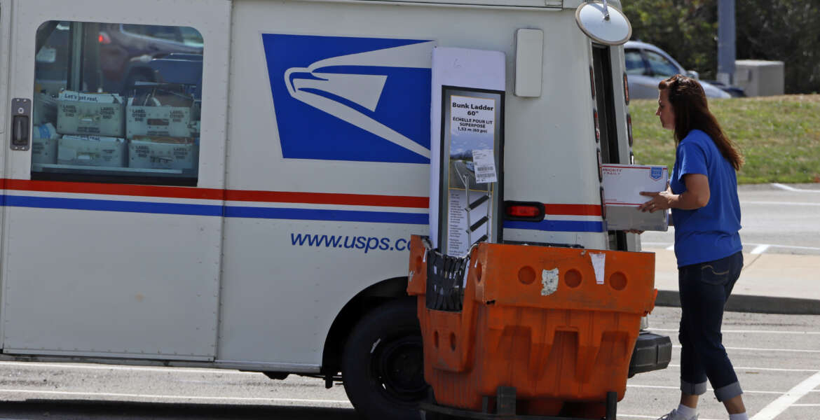 A postal worker loads a delivery vehicle at the United States Post Office in Cranberry Township, Pa., Wednesday, Aug. 19, 2020. (AP Photo/Gene J. Puskar)