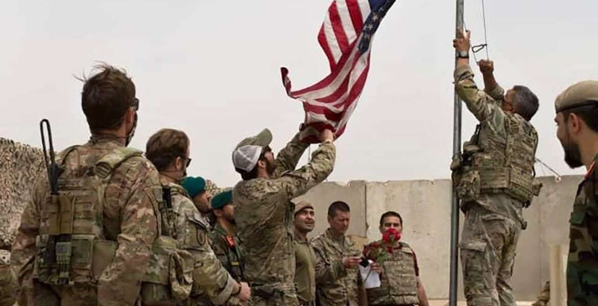 FILE - In this May 2, 2021 file photo, a U.S. flag is lowered as American and Afghan soldiers attend a handover ceremony from the U.S. Army to the Afghan National Army, at Camp Anthonic, in Helmand province, southern Afghanistan. The US and NATO have promised to pay $4 billion a year until 2024 to finance Afghanistan’s military and security forces, which are struggling to contain an advancing Taliban. Already since 2001, the U.S. has spent nearly $89 billion to build, equip and train the forces. (Afghan Ministry of Defense Press Office via AP, File)