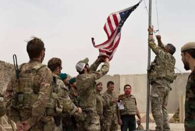 FILE - In this May 2, 2021 file photo, a U.S. flag is lowered as American and Afghan soldiers attend a handover ceremony from the U.S. Army to the Afghan National Army, at Camp Anthonic, in Helmand province, southern Afghanistan. The US and NATO have promised to pay $4 billion a year until 2024 to finance Afghanistan’s military and security forces, which are struggling to contain an advancing Taliban. Already since 2001, the U.S. has spent nearly $89 billion to build, equip and train the forces. (Afghan Ministry of Defense Press Office via AP, File)