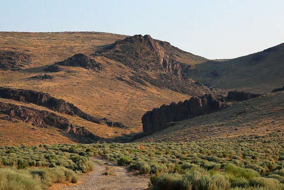 The Montana Mountains loom over Thacker Pass in northern Nevada, July 14, 2021. A federal judge on Friday, July 23, has denied environmentalists' request for a court order temporarily blocking the government from digging trenches for archaeological surveys at a mine planned near the Nevada-Oregon line with the biggest known U.S. deposit of lithium. (Jason Bean/The Reno Gazette-Journal via AP)