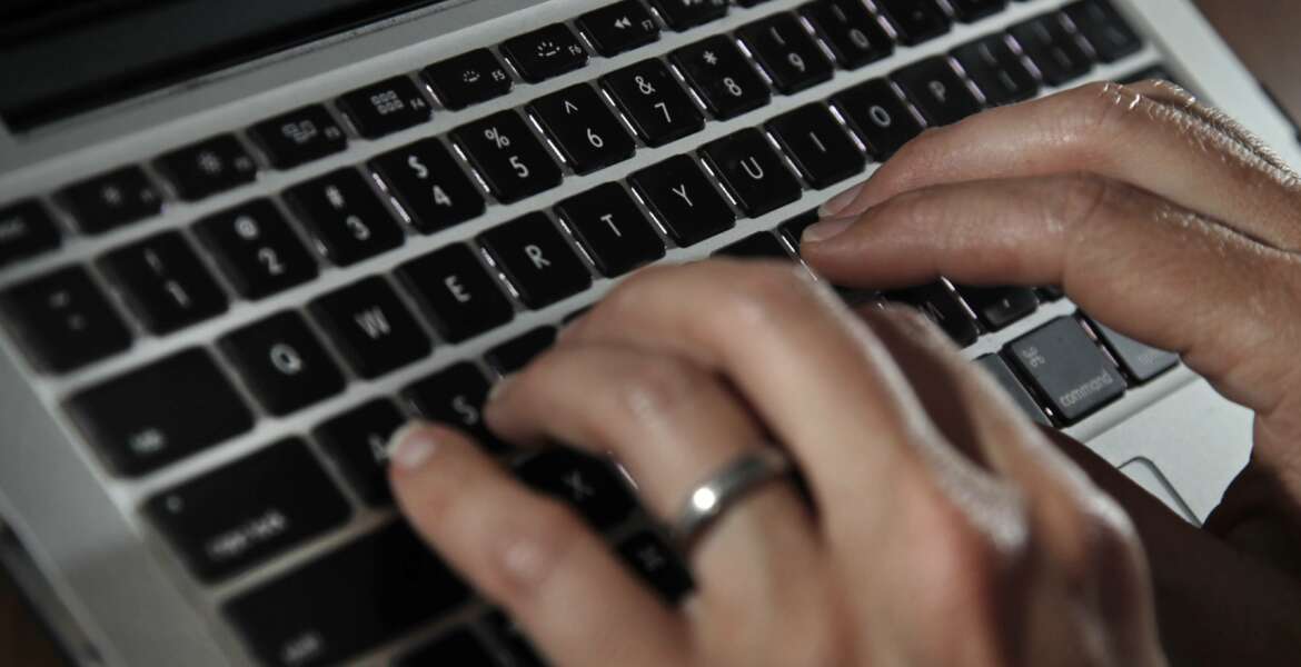 FILE- In this June 19, 2017, file photo, a person types on a laptop keyboard in North Andover, Mass.  A new report by a global media consortium that expands the known target list of the Israeli hacker-for-hire firm NSO Group’s military-grade spyware provoked alarm Monday, July 19, 2021,  among human rights and press freedom activists. They decried the near-complete absence of regulation of commercial surveillance tools.   (AP Photo/Elise Amendola, File)