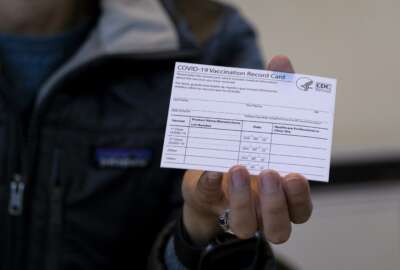 FILE - In this Jan. 10, 2021 file photo, Sarah Gonzalez of New York, a Nurse Practitioner, displays a COVID-19 vaccine card at a New York Health and Hospitals vaccine clinic in the Brooklyn borough of New York.  Workers in New York City-run hospitals and health clinics will have to get vaccinated or get tested weekly under a policy announced Wednesday, July 21,  to battle a rise in COVID-19 cases fueled by the highly contagious delta variant. (AP Photo/Craig Ruttle, File)