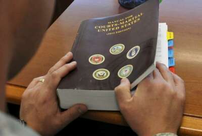 U.S. service member examines a Manual for Courts-Martial. (U.S. Air Force/Staff Sgt. Nicholas Rau)