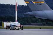 An ambulance stands next to a transport plane carrying people flown out of Afghanistan at Ramstein Air Base, in Ramstein-Miesenbach, Germany, Friday, Aug. 2021.  (Uwe Anspach/dpa via AP)