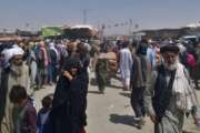 Afghan families wait for transport after entering Pakistan through a border crossing point in Chaman, Pakistan, Tuesday, Aug. 24, 2021. (AP Photo/Jafar Khan)