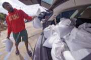 Jawan Williams loads his vehicle with sandbags before landfall of Hurricane Ida at the Frederick Sigur Civic Center in Chalmette, La., which is part of the Greater New Orleans metropolitan area, Saturday, Aug. 28, 2021.  The storm is expected to bring winds as high as 140 mph when it slams ashore late Sunday.   (AP Photo/Matthew Hinton)