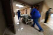 FILE - In this Wednesday, Aug. 18, 2021 file photo, Medical staff move a COVID-19 patient who died to a loading dock to hand off to a funeral home van, at the Willis-Knighton Medical Center in Shreveport, La. Louisiana hospitals already packed with patients from the latest coronavirus surge are now bracing for a powerful Category 4 hurricane, which is expected to crash ashore Sunday, Aug. 28, 2021. (AP Photo/Gerald Herbert, File)