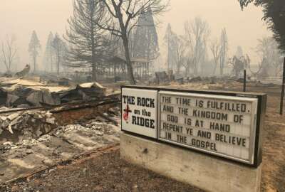 A sign for The Rock on the Ridge Church is seen in Greenville, Calif., after the Dixie Wildfires Thursday, Aug. 12, 2021. California's largest single wildfire in recorded history is running through forestlands as fire crews try to protect rural communities from flames that have destroyed hundreds of homes. The Dixie Fire is the largest single fire in California history and the largest currently burning in the U.S. It is about half the size of the August Complex, a series of lightning-caused 2020 fires across seven counties that were fought together and that state officials consider California's largest wildfire overall. (AP Photo/Eugene Garcia)