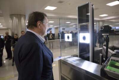 As part of CBP’s one-to-one biometric facial recognition testing on inbound, international flights, a traveler has his photo taken and compared against his passport photo to confirm his identity at Dulles Airport. Photo by Glenn Fawcett

