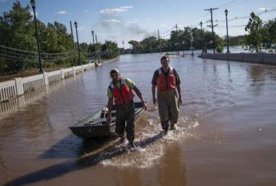 United States Geological Survey workers push a boat as they look for residents on a street flooded as a result of the remnants of Hurricane Ida in Somerville, NJ., Thursday, Sept. 2, 2021. (AP Photo/Eduardo Munoz Alvarez)