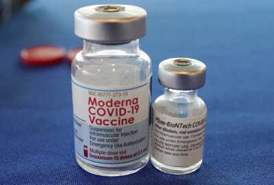 FILE - This Sept. 21, 2021 file photo shows vials of the Pfizer and Moderna COVID-19 vaccines in Jackson, Miss. Billions more in profits are at stake for some vaccine makers as the U.S. moves toward dispensing COVID-19 booster shots to shore up Americans' protection against the virus. (AP Photo/Rogelio V. Solis)
