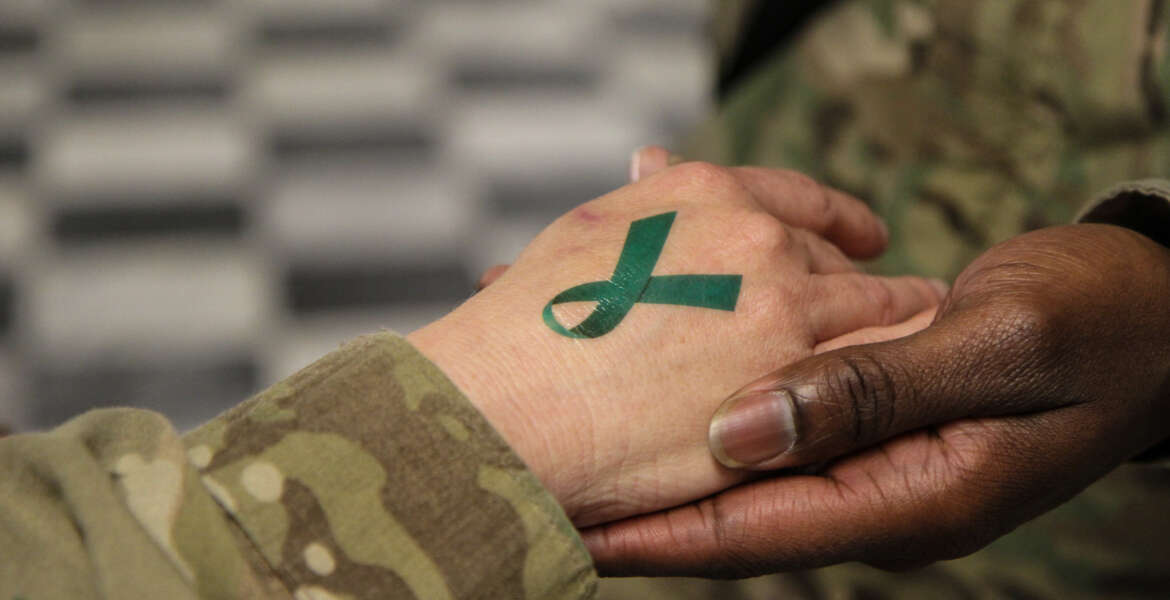 U.S. Army Sgt. 1st Class Tyrone Lawrence, right, places a temporary teal ribbon tattoo on a Soldier's hand at the Koele dining facility at Bagram Airfield in Parwan province, Afghanistan, April 2, 2014. The teal ribbon was the symbol of sexual assault survivors and awareness. (DoD photo by Staff Sgt. Kelly Simon, U.S. Army/Released)


