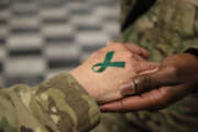 U.S. Army Sgt. 1st Class Tyrone Lawrence, right, places a temporary teal ribbon tattoo on a Soldier's hand at the Koele dining facility at Bagram Airfield in Parwan province, Afghanistan, April 2, 2014. The teal ribbon was the symbol of sexual assault survivors and awareness. (DoD photo by Staff Sgt. Kelly Simon, U.S. Army/Released)

