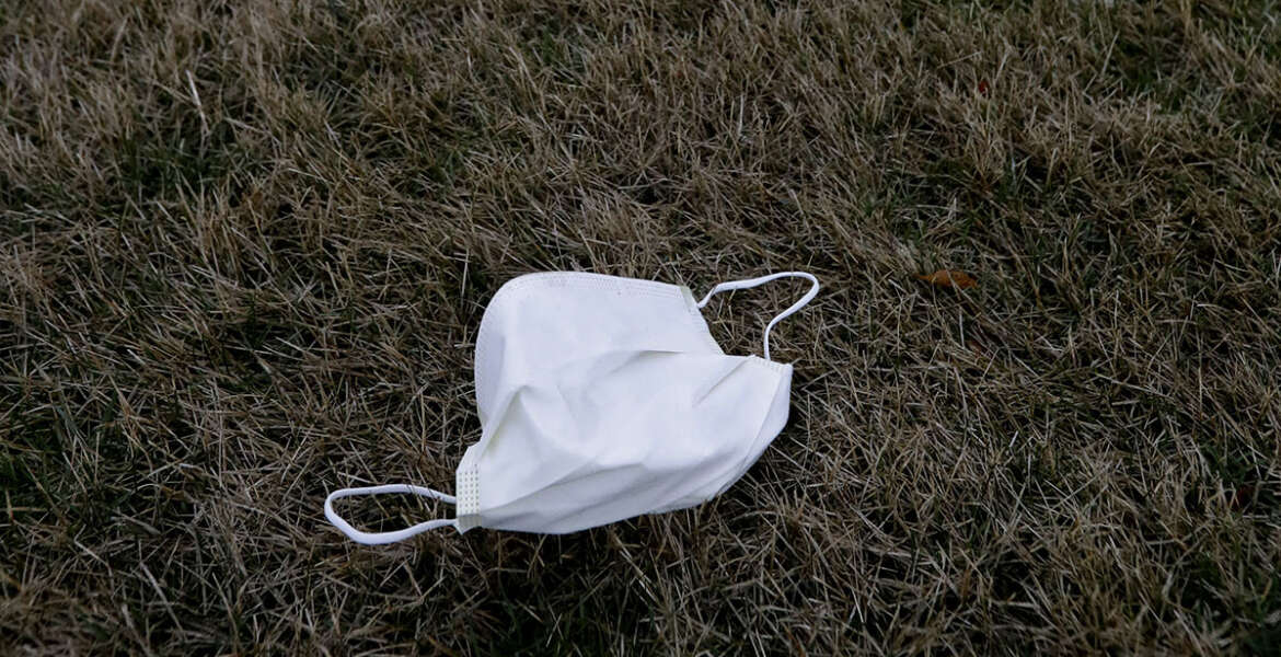 FILE - In this March 19, 2020, file photo, a face mask lies on the ground outside the Chateau Nursing and Rehabilitation Center in Willowbrook, Ill. Burgeoning coronavirus outbreaks at this and other nursing homes in Washington, New Jersey and elsewhere are laying bare the risks of the industry’s long-running problems, including a struggle to control infections and a staffing crisis that relies on poorly paid aides who can't afford to stay home sick. (AP Photo/Nam Y. Huh, File)