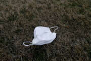 FILE - In this March 19, 2020, file photo, a face mask lies on the ground outside the Chateau Nursing and Rehabilitation Center in Willowbrook, Ill. Burgeoning coronavirus outbreaks at this and other nursing homes in Washington, New Jersey and elsewhere are laying bare the risks of the industry’s long-running problems, including a struggle to control infections and a staffing crisis that relies on poorly paid aides who can't afford to stay home sick. (AP Photo/Nam Y. Huh, File)