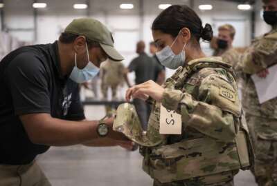 In this image provided by the U.S. Army, Sgt. Katiushka Rivera, a soldier assigned to the 82nd Airborne gets fitted for a modular scalable vest (MSV) during a fielding event in Fort Bragg, N.C., on Sept. 13, 2021. The Army for the first time, began handing out armor that now comes in three additional sizes, and can be adjusted in multiple ways to fit better and allow soldiers to move faster and more freely. The so-called “modular, scalable vest” was is being distributed to soldiers at Fort Bragg, N.C., along with new versions of the combat shirt that are tailored to better fit women, with shorter sleeves and a flare at the bottom where it hits their hips. (Jason Amadi/U.S. Army via AP)