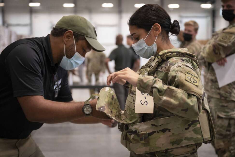 In this image provided by the U.S. Army, Sgt. Katiushka Rivera, a soldier assigned to the 82nd Airborne gets fitted for a modular scalable vest (MSV) during a fielding event in Fort Bragg, N.C., on Sept. 13, 2021. The Army for the first time, began handing out armor that now comes in three additional sizes, and can be adjusted in multiple ways to fit better and allow soldiers to move faster and more freely. The so-called “modular, scalable vest” was is being distributed to soldiers at Fort Bragg, N.C., along with new versions of the combat shirt that are tailored to better fit women, with shorter sleeves and a flare at the bottom where it hits their hips. (Jason Amadi/U.S. Army via AP)