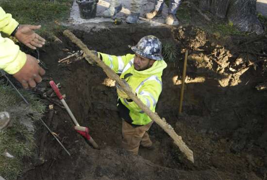 A cut lead pipe is pulled from a dig site for testing at a home in Royal Oak, Mich., on Tuesday, Nov. 16, 2021. Communities with lead pipes could see higher test results for lead in their tap water if a new method of water sampling goes into effect. The Detroit suburb of Royal Oak historically had low test results but it had to notify the public of a problem after the state mandated new sampling methods. (AP Photo/Carlos Osorio)